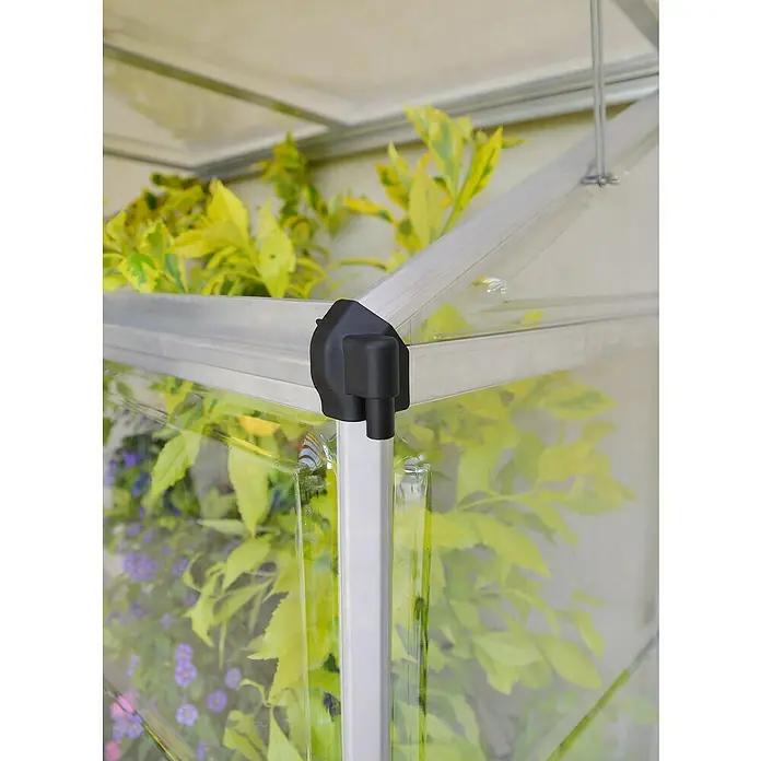 Palram – Canopia Invernadero Lean To - Medidas ext. (An x Pr): 125 x 63,5 cm, Material de la pared lateral: Plástico, 0,7 mm, Plateado - Primer plano de una estructura de invernadero con un conector negro y paneles transparentes, rodeado de exuberante vegetación.