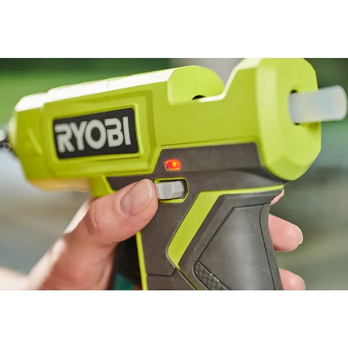 Ryobi ONE+ Akku-Heißklebepistole RGLU18-0 - 18 V, Ohne Akku, Durchmesser Klebepatrone: 11 mm - 12 mm - Nahaufnahme einer RYOBI Akku-Heißklebepistole in Grün, die von einer Hand bedient wird, mit roter Bereitschaftsanzeige.
