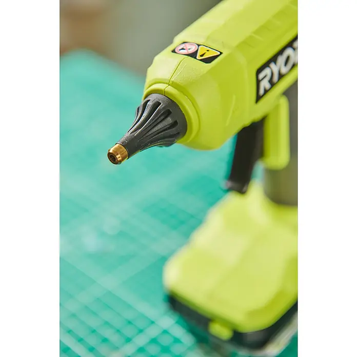Ryobi ONE+ Akku-Heißklebepistole RGLU18-0 - 18 V, Ohne Akku, Durchmesser Klebepatrone: 11 mm - 12 mm - Nahaufnahme einer grünen Ryobi Akku-Heißklebepistole auf einem grünen Schneidebrett.