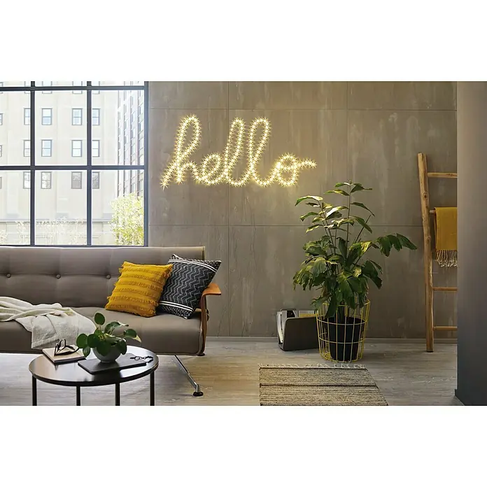 Paulmann LED-Band FlexLED 3D Basisset - Länge: 3 m, Lichtfarbe: Warmweiß, 8 W, 960 lm - Ein stilvolles Wohnzimmer mit einem grauen Sofa, einem runden Tisch und einer leuchtenden "Hallo"-Wanddekoration für eine gemütliche Atmosphäre.