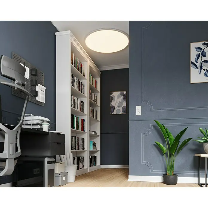 Tween Light LED-Panel rund RC-CCT-DIM - 58 W, Ø x H: 100 x 5 cm, Weiß, Mehrfarbig - Einblick in ein Arbeitszimmer mit Bücherregal, Schreibtisch und Zimmerpflanze unter einer hellen Deckenleuchte.