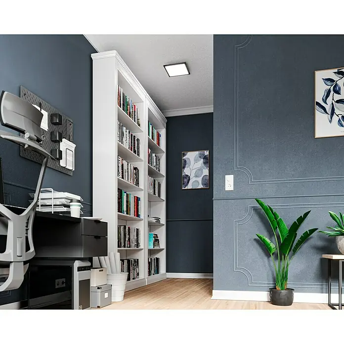 Tween Light LED-Panel CCT-RC-DIM - 15,5 W, L x B x H: 29,5 x 29,5 x 5 cm - Ein elegantes Arbeitszimmer mit einem großen, weißen Bücherregal voller Bücher, einem modernen Schreibtisch und stilvollen dekorativen Elementen.