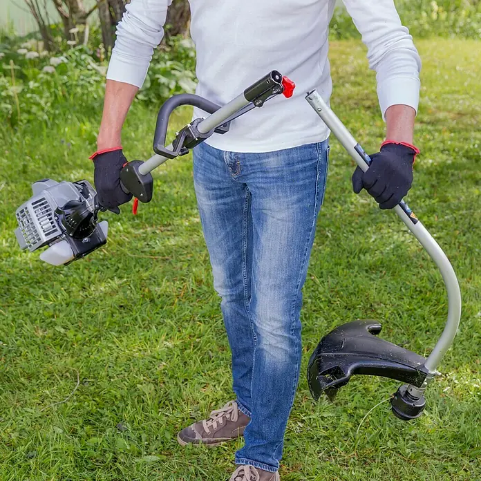 AL-KO Benzin-Motorsense BC 223 L-S - 700 W, Schnittbreite Faden: 41 cm - Eine Person hält einen auseinandergenommenen Rasentrimmer im Freien. Der Trimmer ist silbern mit einem schwarzen Kopf.