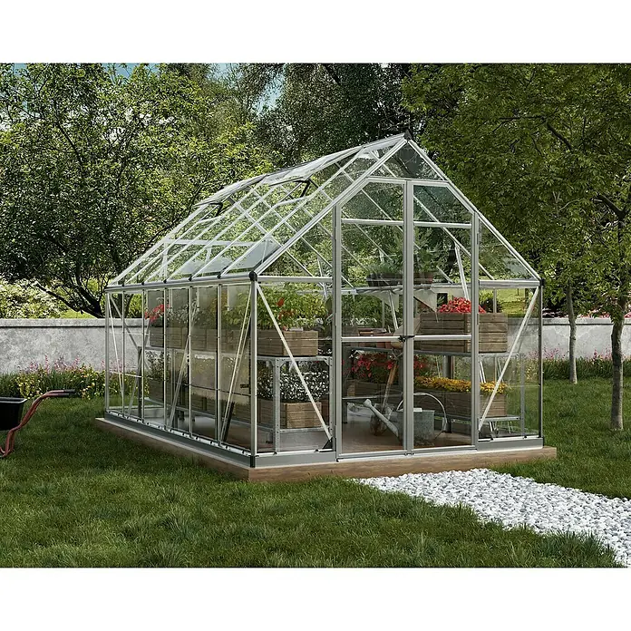 Palram – Canopia Invernadero Octave - Medidas ext. (An x Pr): 244 x 367 cm, Material de la pared lateral: Plástico, 0,7 mm, Plateado - Un invernadero con plantas, estanterías de madera y herramientas de jardinería en un jardín. El invernadero es de vidrio y metal.