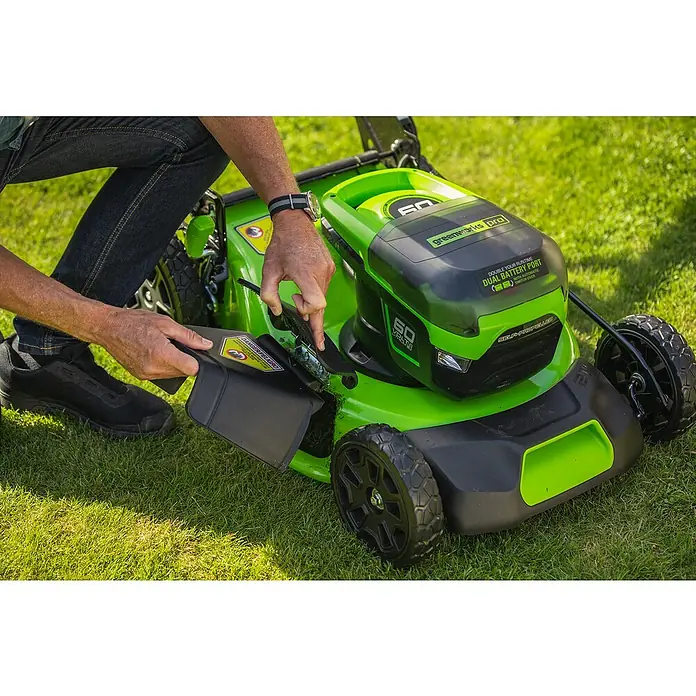 Greenworks 60V Akkusystem Akku-Rasenmäher GD60LM46SP - 60 V, 1 Akku, 4 Ah, Schnittbreite: 46 cm - Ein Mann befestigt einen Grasfangsack an einem Greenworks Pro Rasenmäher, der für effiziente Rasenpflege auf einem Rasen steht.