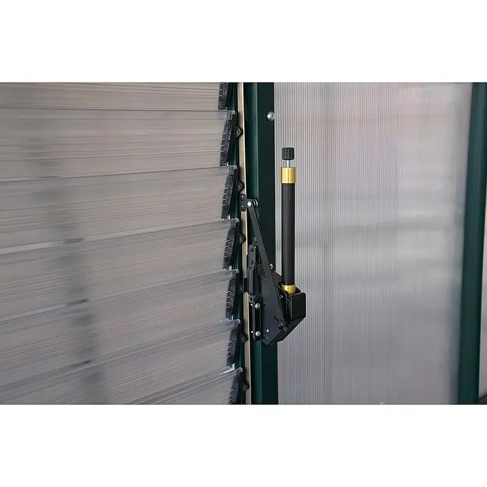 Palram – Canopia Abridor de ventana - L x An: 62 x 6 cm - Primer plano de un abridor de ventanas manual negro en una ventana de invernadero, utilizado para la ventilación y el control de la temperatura.