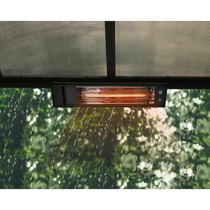 Palram – Canopia Calefacción para invernadero - 73,5 x 15,5 x 7,3 cm - Primer plano de un calentador de patio encendido bajo un techo en la lluvia.