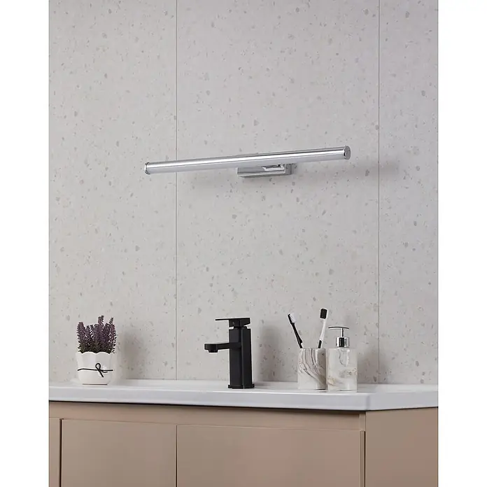 Eglo LED-Spiegelleuchte Vadumi - 11 W, L x B x H: 60 x 12,5 x 5 cm, Chrom, Neutralweiß - Nahaufnahme einer modernen Badezimmerleuchte aus Chrom, die über einem Waschbecken mit Armatur, Seifenspender und Topfpflanze montiert ist.
