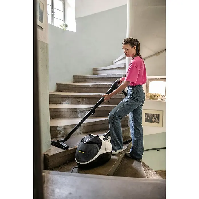 Kärcher Dampfsauger SV 7 - 2.200 W - Eine Frau reinigt eine Treppe mit einem Kärcher Dampfreiniger. Der Dampfreiniger erzeugt Dampf, während er die Treppe hochfährt.