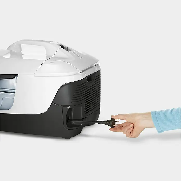 Kärcher Elektro-Staubsauger DS 6 - 650 W - Nahaufnahme eines weißen Kärcher Staubsaugers, an den ein Stecker angeschlossen wird, vor einem hellen Hintergrund.