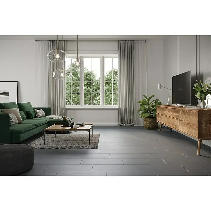 Feinsteinzeugfliese My Style - 30 x 60 cm, Grau, Matt - Ein modernes Wohnzimmer mit einem grünen Sofa, einem Holztisch und eleganten Pendelleuchten. Der graue Fliesenboden rundet das stilvolle Ambiente ab.