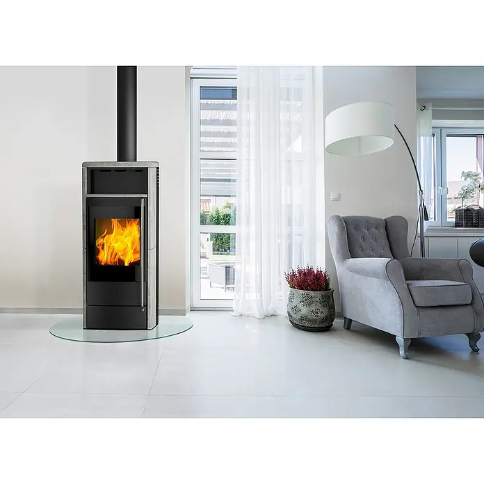 Fireplace Kaminofen Teramo RLU - 6 kW, Raumheizvermögen: 108 m³, Material Verkleidung: Speckstein, Schwarz - Moderne Kaminofen-Einheit mit Glasbodenplatte. Der Kaminofen ist in Grau gehalten und brennt mit einem lebhaften, orangefarbenen Feuer.