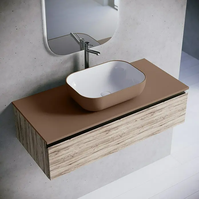 Lavabo y encimera Stadium Bicolor - 46 x 101 cm, Rosa california/Blanco - Elegante lavabo de baño con exterior marrón e interior blanco, montado sobre un mueble con vetas de madera.