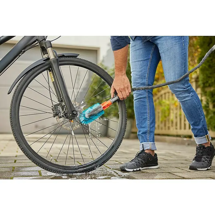 Gardena Cleansystem Fahrrad-Bürsten-Set - 2 -tlg. - Der Mann reinigt das Fahrrad mit der GARDENA Waschbürste, die eine effiziente und schonende Reinigung gewährleistet.\n