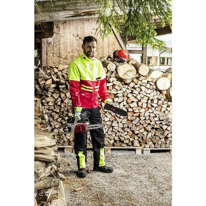 AL-KO 36V Akku-Kettensäge CS 4030 - 36 V, Li-Ionen, Ohne Akku, Schwertlänge: 30 cm - Ein Mann in Arbeitskleidung mit einer Al-Ko Akku-Kettensäge vor einem Holzstapel.