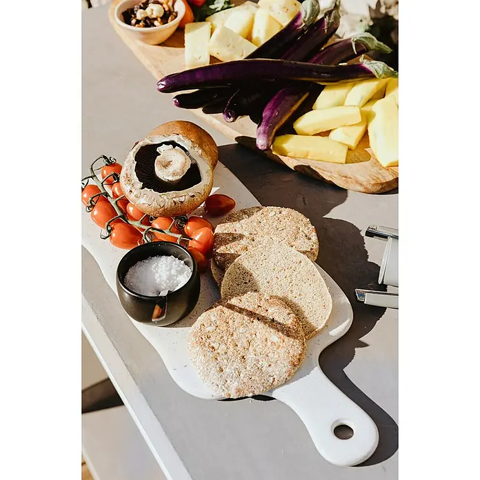 Tuozi Venit Outdoorküchen-Modul Seitenschrank - Weiß-Grau, B x T x H: 110 x 47 x 88 cm - Ein Arrangement mit Champignons, Tomaten, Salz, Brotscheiben, Auberginen, Käse und Nüssen auf einem Tisch präsentiert.