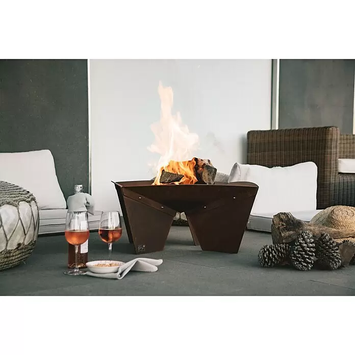 Tuozi Feuerschale Syrtis - L x B x H: 65 x 65 x 31,5 cm, Cortenstahl - Cortenstahl-Feuerschale mit Feuer, umgeben von Outdoor-Sitzgelegenheiten, Getränken und Snacks.