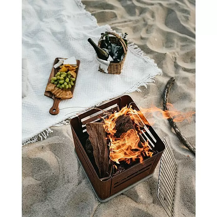 Tuozi Feuerschale Tharsis - L x B x H: 37,5 x 37,5 x 40 cm, Cortenstahl - Rostbraune, quadratische Feuerschale mit brennendem Holz und Grillrost am Strand.