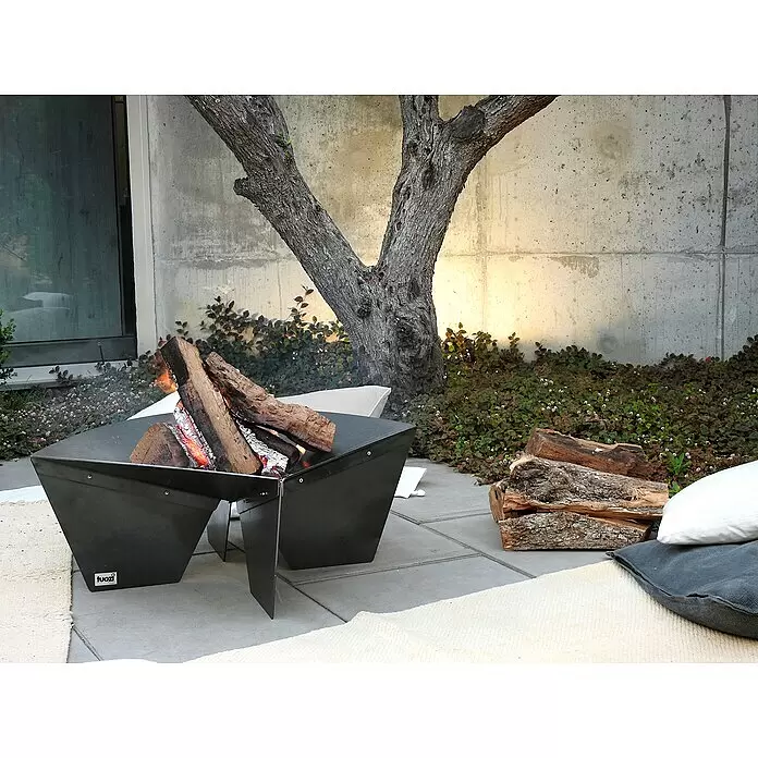 Tuozi Feuerschale Syrtis - L x B x H: 65 x 65 x 31,5 cm, Cortenstahl - Schwarze Metall-Feuerstelle mit brennendem Holz auf einer Terrasse.