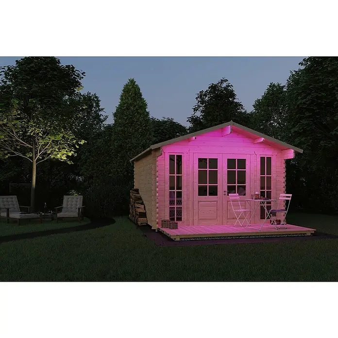 Paulmann SimpLED LED-Band-Set Outdoor RGB - Länge: 300 cm, Lichtfarbe: RGB, 11 W, 157 lm, 230 V - Das Bild zeigt ein hölzernes Gartenhaus mit rosa Beleuchtung, umgeben von Bäumen und einem Rasen. Eine kleine Terrasse mit Tisch und Stühlen lädt zum Verweilen ein.