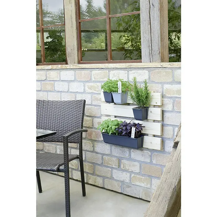 Geli Pflanzkasten-Einsatz Easy - Außenmaß (L x B x H): 37 x 10 x 10 cm, Kunststoff, Anthrazit - Kreative Kräutergarten-Lösung: Kräuter sind in Töpfen auf einem Holzregal an einer Ziegelwand befestigt, daneben ein grauer Stuhl.