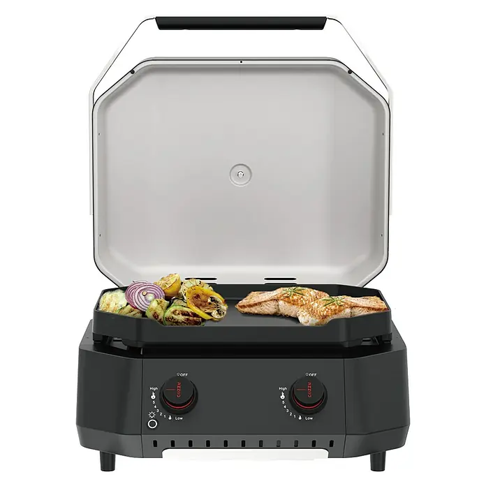 Cozze Plancha-Grill G 500 - Grillfläche (B x T): 53,5 x 41,8 cm, 5 kW, Schwarz - Ein Cizzle Grill mit Gemüse und Fisch auf dem Grill, der auf einer schwarzen Basis mit Bedienknöpfen steht.