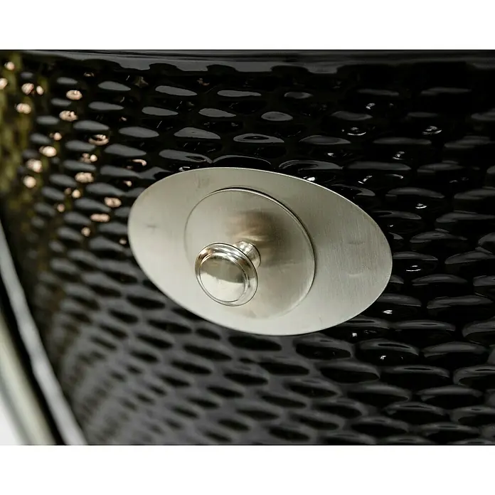 Flame Rock  Holzkohlegrill Kamado 24 Pro - Durchmesser Grillfläche: 52 cm, Schwarz - Detailaufnahme einer schwarzen Keramikgrill mit silberfarbenen Metallelement, die ein raffiniertes und stilvolles Design aufweist.