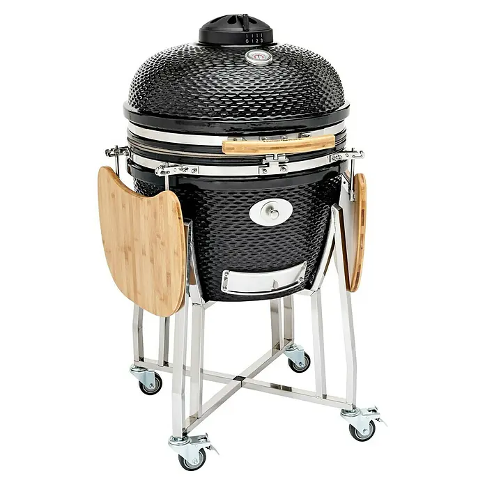 Flame Rock  Holzkohlegrill Kamado 24 Pro - Durchmesser Grillfläche: 52 cm, Schwarz - Nahaufnahme eines schwarzen Keramikgrills mit zwei Holztischen an den Seiten und einem verchromten Ständer mit Rollen.