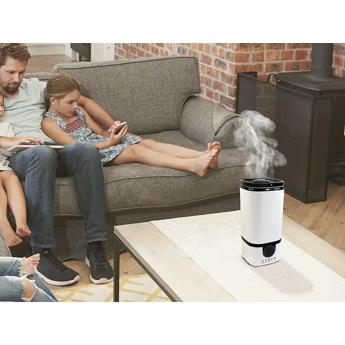 Purline Humidificador Hydro 15 - 17 x 19 x 37 cm, Blanco - Humidificador en la sala de estar: El humidificador blanco garantiza un clima interior agradable. La familia se relaja en el sofá.