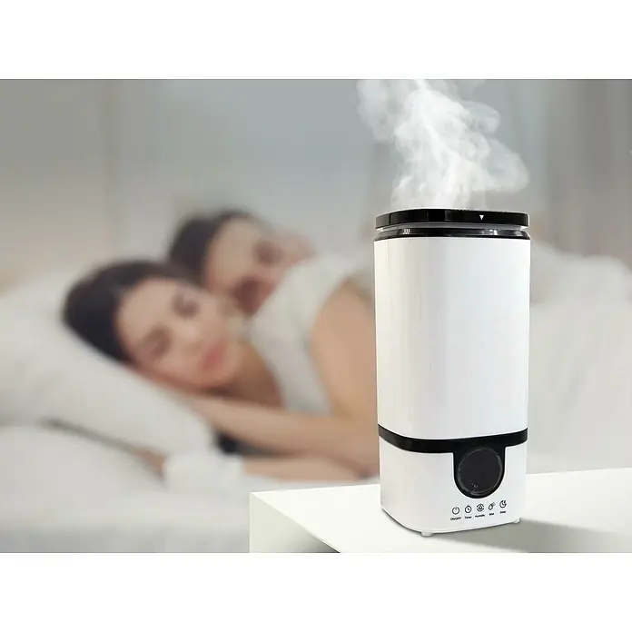 Purline Humidificador Hydro 15 - 17 x 19 x 37 cm, Blanco - Esta imagen muestra un humidificador en un dormitorio, promoviendo un ambiente confortable y aumentando la humedad del aire.