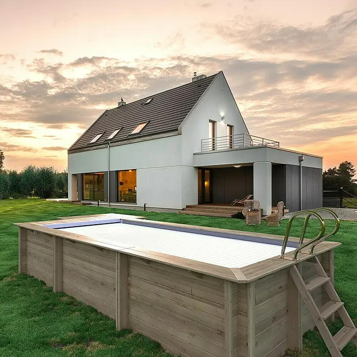 myPool Holz-Pool Urban - 670 x 301 x 133 cm, 11.800 l, Braun, Grau - Holzpool mit Abdeckung und Leiter vor einem modernen Haus. Der Pool ist der Mittelpunkt des Bildes und lädt zum Baden ein.