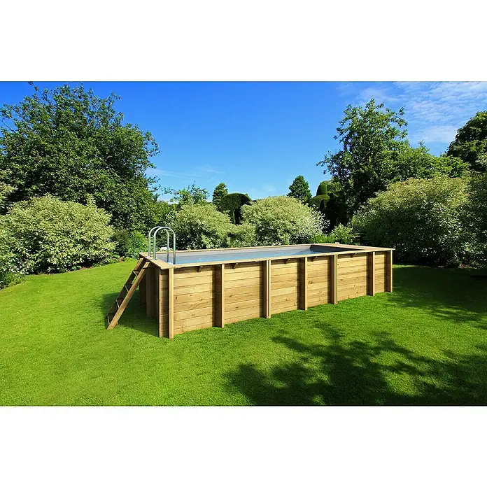 myPool Holz-Pool Pool`N Box - 610 x 237 x 133 cm, 12.000 l, Braun, Grau - Ein rechteckiger Holzpool mit Leiter steht auf einem grünen Rasen, umgeben von Bäumen und Sträuchern.