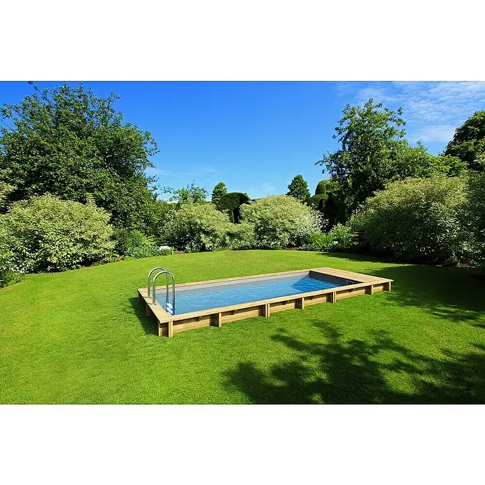 myPool Holz-Pool Pool`N Box - 610 x 237 x 133 cm, 12.000 l, Braun, Grau - Eine rechteckige Holzpool eingebettet in einen üppigen grünen Rasen vor einem friedlichen Gartenhintergrund mit blauem Himmel.