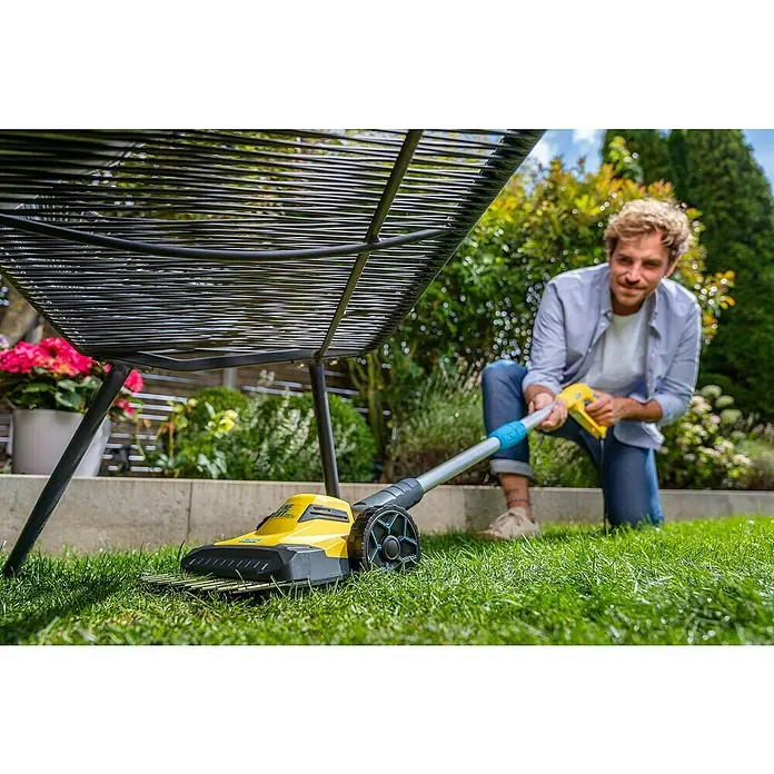 Gloria Elektro-Rasenmäher FineCut 230V - 60 W, Schnittbreite: 25 cm - Mann benutzt einen gelben Vertikutierer, um seinen Rasen zu pflegen.