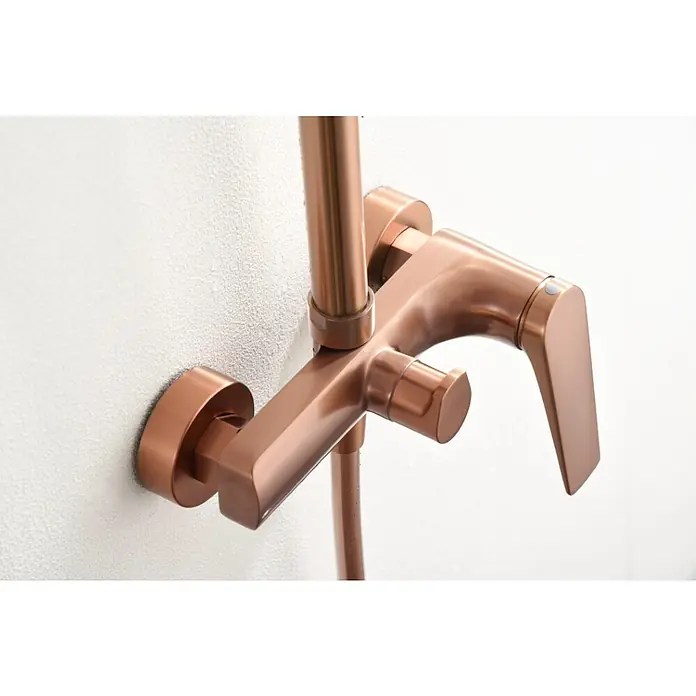 Imex Delos Sistema de ducha - Grifo monomando, Oro rosa - Primer plano de un mezclador de ducha de oro rosa brillante montado en una pared blanca, mostrando un diseño elegante y moderno.