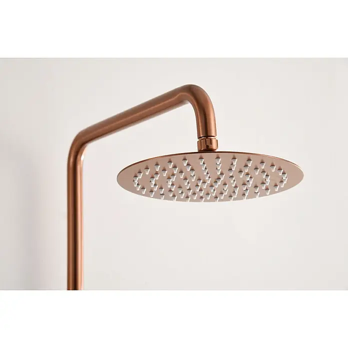 Imex Delos Sistema de ducha - Grifo monomando, Oro rosa - Primer plano de un moderno cabezal de ducha redondo color cobre con boquillas blancas sobre un fondo blanco liso.