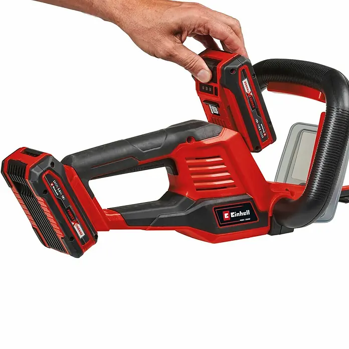 Einhell Power X-Change 18V Akku-Heckenschere GE-CH 36/61 - 18 V, Li-Ionen, Ohne Akku, Schnittlänge: 61 cm - Akku-Heckenschere von Einhell mit Hand, die einen Akku einsetzt. Das Gerät ist rot und schwarz.