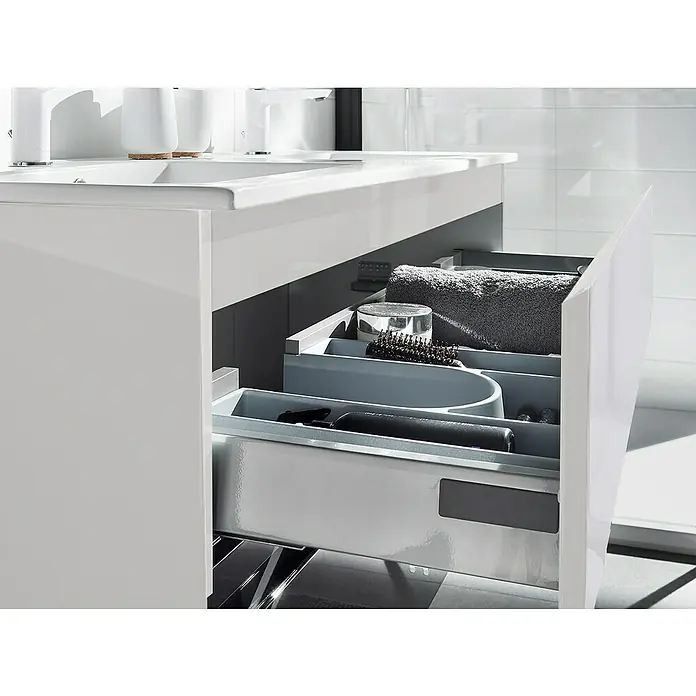 Camargue Espacio Waschtischunterschrank - 120 x 46 x 60 cm, 2 Schubkästen, Gama weiß glänzend - Ein offener Badezimmerschrank mit verschiedenen Badartikeln, darunter Handtücher, Bürsten und Flaschen, die ordentlich in Fächern verstaut sind.