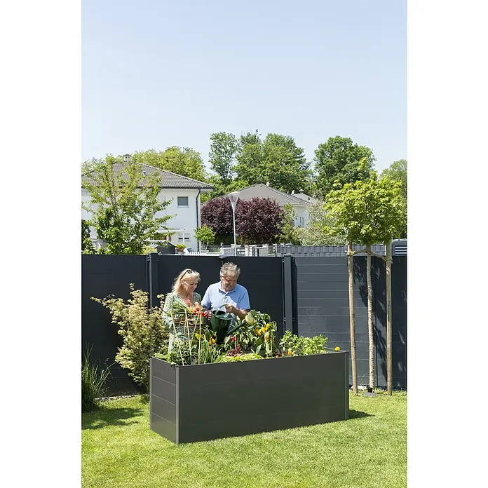Guardi Hochbeet - 140 x 70 x 76 cm, Metall, Anthrazit - Ein erhöhter, dunkelgrauer Pflanzkasten mit verschiedenen Pflanzen und Gemüse, umgeben von einem Paar bei der Gartenarbeit.