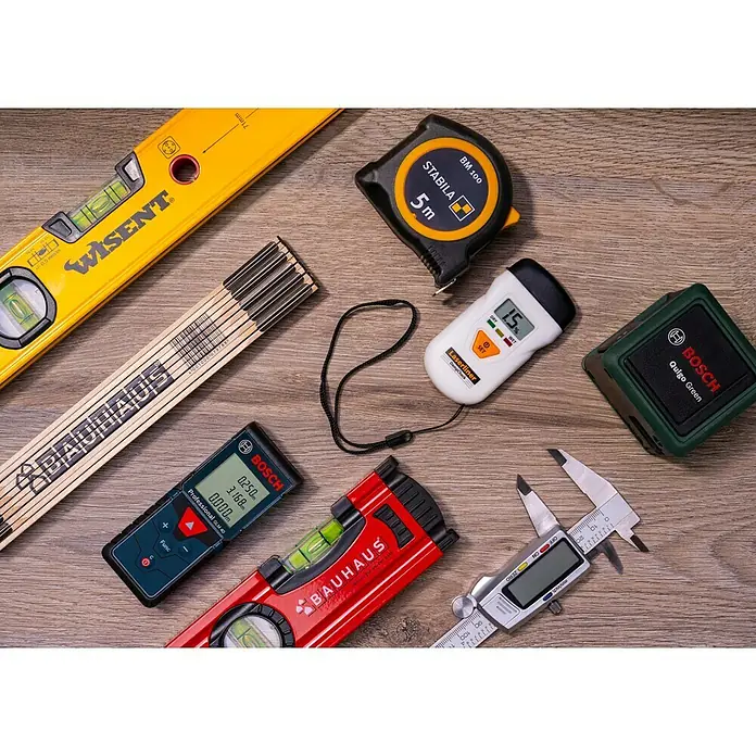 Alpha Tools Digitaler Messschieber - Messbereich: 0 - 150 mm, Stahl - Eine Nahaufnahme von verschiedenen Messwerkzeugen, darunter eine Wasserwaage, ein Rollbandmaß und ein digitaler Messschieber.