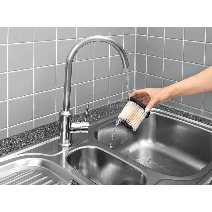 Kärcher Patronenfilter - Passend für: Kärcher Staubsauger VC 5 - Eine Hand wäscht einen schmutzigen Staubsaugerfilter unter einem Wasserhahn in einer Spüle, um ihn zu reinigen und wiederzuverwenden.