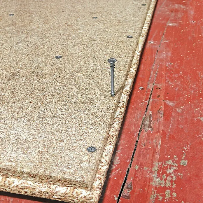 Spax Verlegeschraube T-Star PlusØ x L: 4,5 x 60 mm, WIROX Oberfläche, 150 Stk., Fixiergewinde - Nahaufnahme einer Spanplatte mit einem hervorstehenden Befestigungselement, die die Materialzusammensetzung und Befestigungsmethode hervorhebt.
