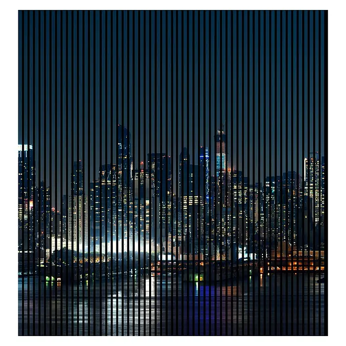 Profiles and more Akustikpaneel Manhatten - 2.400 x 2.253 x 19 mm - Skyline bei Nacht mit vertikalen Streifen. Die Wolkenkratzer spiegeln sich im Wasser, durchzogen von dunklen, vertikalen Linien.