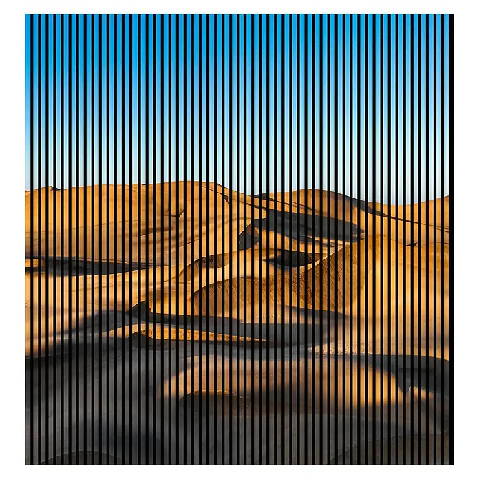 Profiles and more Akustikpaneel Dünen - 2.400 x 2.253 x 19 mm - Abstraktes Wüstenbild mit vertikalen schwarzen Streifen, die das Sanddünenmuster unterbrechen, und blauem Himmel oben.