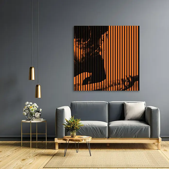 Profiles and more Akustikpaneel Gitarrist - 1.195 x 1.133 x 19 mm - Ein stilvolles Wohnzimmer mit einem grauen Sofa und einem markanten orangefarbenen Wandbild. Die goldenen Lampen ergänzen das moderne Design.