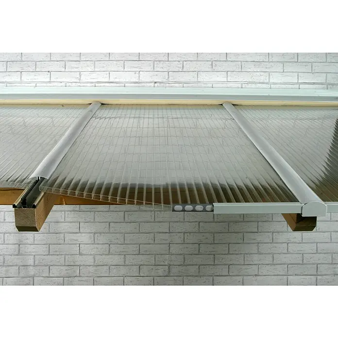 PLEXIGLAS® Acrylglas-Stegplatte proTerra - 2.500 x 980 x 16 mm, Acrylglas (PMMA), Transparent - Nahaufnahme einer Polycarbonat-Überdachung mit Aluminiumprofilen vor einer weißen Ziegelwand. Lichtdurchlässig und stabil.