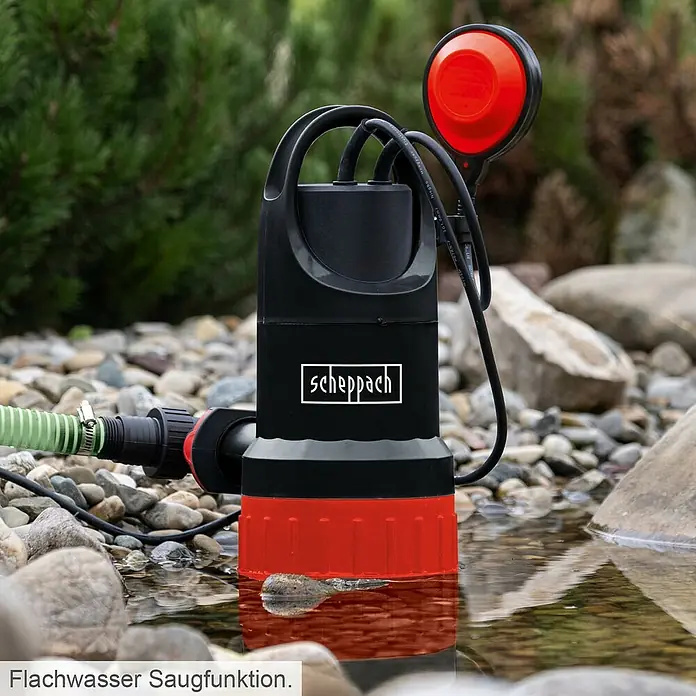 Scheppach Schmutzwasserpumpe DWP750 - Max. Fördermenge: 20.000 l/h - Scheppach Tauchpumpe im Einsatz. Die Pumpe ist schwarz und rot und steht in einem Gewässer, umgeben von Steinen.