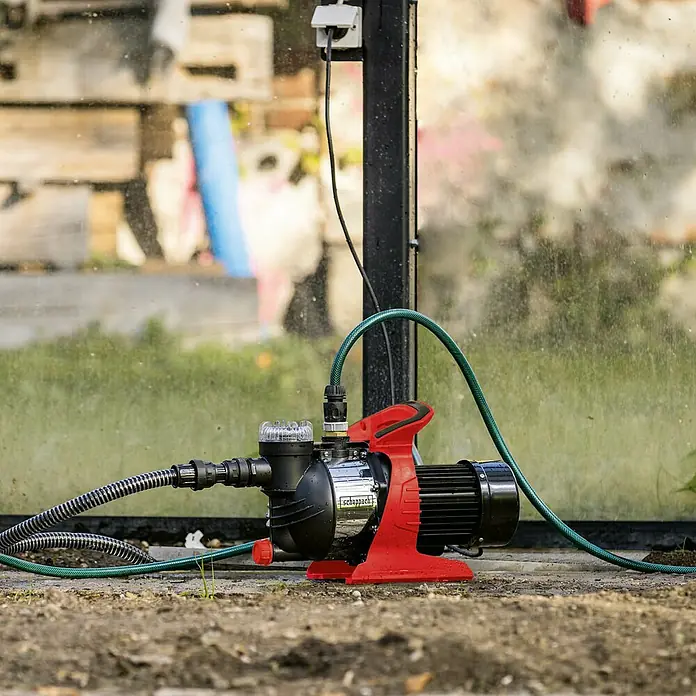 Scheppach Gartenpumpe GP1400JET - 1.300 W, Max. Fördermenge: 6.000 l/h - Bild einer Scheppach Gartenpumpe auf einem Gartengrundstück, die für die Bewässerung oder Entwässerung verwendet werden kann.
