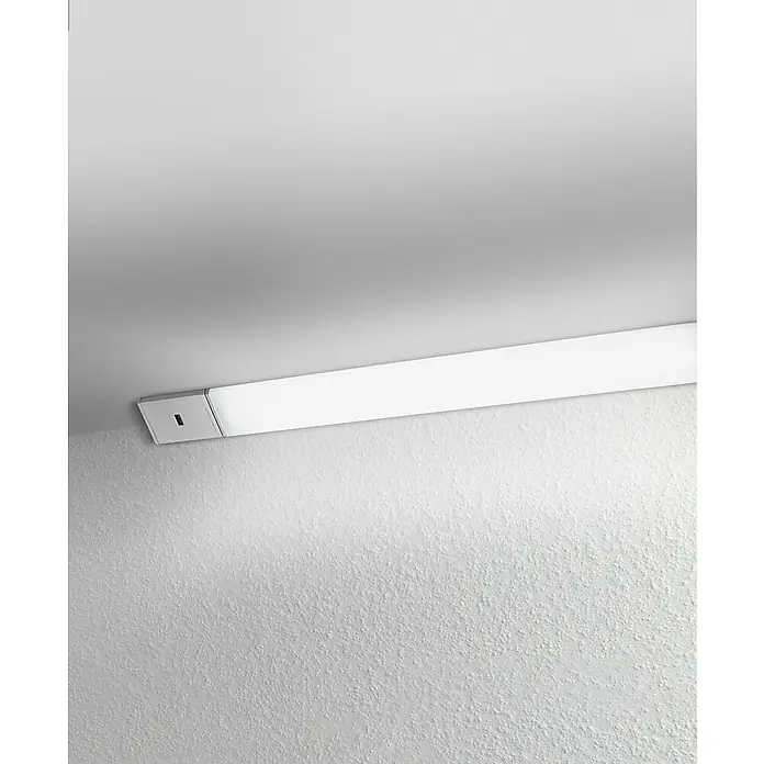 Ledvance Lámpara fluorescente LED Cabinet Corner - L x An x Al: 35 x 4,07 x 2,3 cm, Color de luz: Blanco cálido, 1 ud. - Una lámpara de pared blanca rectangular larga está montada bajo un techo blanco y emite una luz brillante y uniforme.