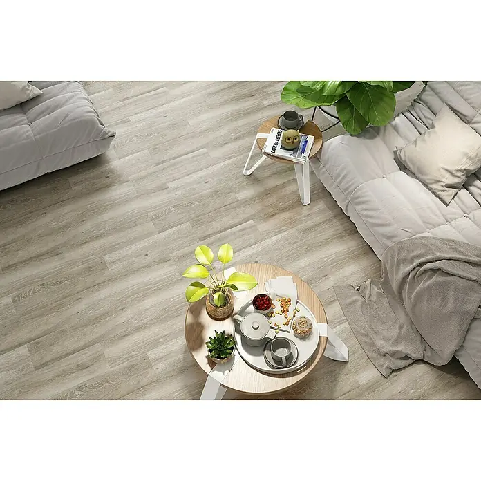 Pavimento cerámico Atelier - 19 x 57 cm, Taupe, Mate - Apartamento moderno y luminoso con suelo de imitación a madera y acogedora zona de estar, decorado con plantas y mesas pequeñas para un ambiente relajado.